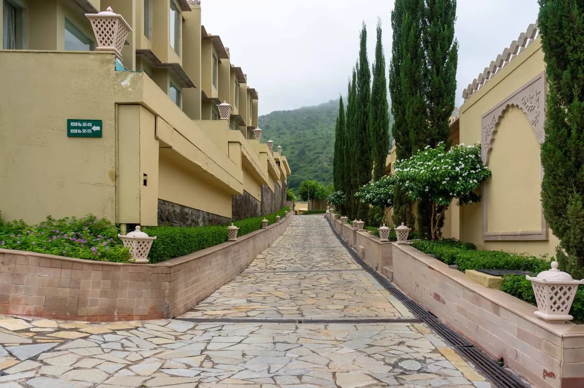 Elegant resort pathway with greenery and mountain backdrop in Kumbhalgarh, India